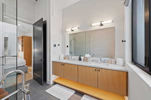 Bathroom with tile patterned flooring, vanity, and walk in shower