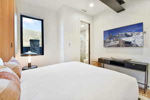 Bedroom featuring hardwood / wood-style floors and ensuite bathroom