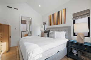 Bedroom featuring lofted ceiling and light wood-type flooring