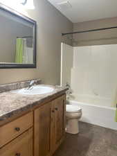 Main bathroom with a large vanity, toilet, and shower / tub combo