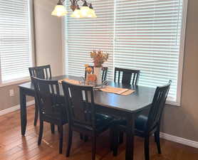 Spacious dining area with a chandelier and hardwood flooring