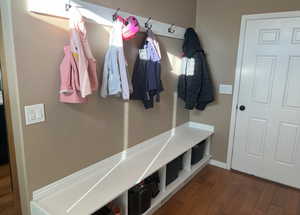 Spacious mudroom with 4 cubbies, wall hooks and hardwood floors located right off of the garage entrance.