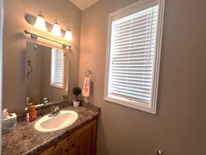 Half bath with a full vanity that has plenty of counter space and storage, conveniently located next to the mudroom