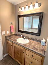 Master bathroom features a large vanity with plenty of counter space and storage area, tile floors, a separate toilet room and a walk-in closet.