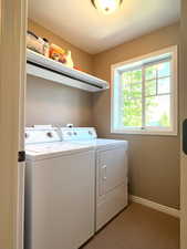 Laundry room with custom corner shelves, shelving above the washer and dryer and a clothes hanging rod