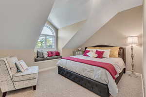 Carpeted bedroom featuring lofted ceiling