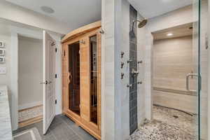 Bathroom featuring a shower with door & dry sauna