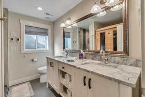 Bathroom featuring a shower with door, vanity, and toilet