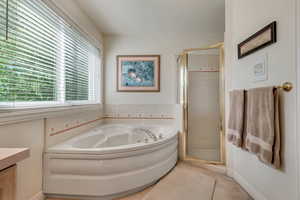 Master Bathroom with vanity, shower with separate bathtub, and tile patterned floors