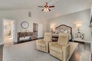 Master Bedroom featuring ceiling fan, ensuite bathroom, dark wood-type flooring, and high vaulted ceiling