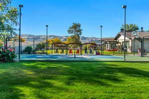 View of Pickle Ball court featuring basketball hoop, a yard, and a mountain view