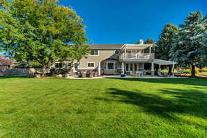 Rear view of property with a lawn, a pergola, and a patio area