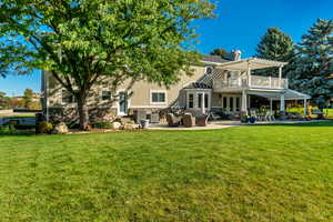 Back of property featuring an outdoor hangout area, a pergola, and a lawn