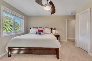 Carpeted bedroom featuring ceiling fan