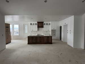 Kitchen featuring dark brown cabinets, a center island, and white cabinetry