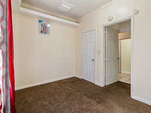 Spare room featuring dark colored carpet