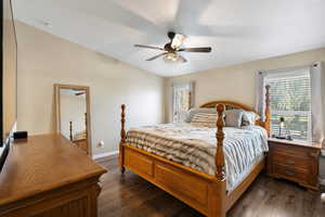 Bedroom featuring vaulted ceiling, dark hardwood / wood-style floors, and ceiling fan