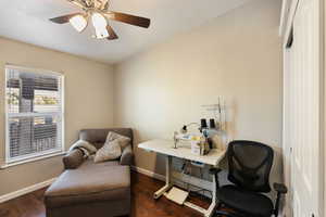 Home office featuring ceiling fan and dark hardwood / wood-style flooring