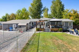 Rear view of property with a deck and a lawn