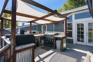 Wooden terrace featuring french doors and area for grilling