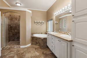 Bathroom featuring shower with separate bathtub, vanity, and crown molding