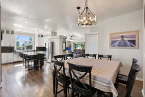 Dining space featuring a textured ceiling, ceiling fan with notable chandelier, dark hardwood / wood-style flooring, and sink