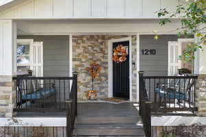 Doorway to property featuring covered porch