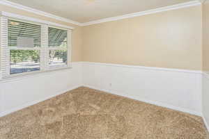 Bedroom with ornamental molding and carpet floors