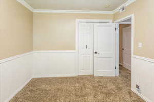 Bedroom with carpet floors, a closet, and crown molding