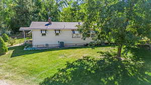 Exterior space with central AC unit and a lawn