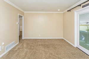 Carpeted empty room featuring a textured ceiling and ornamental molding