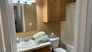 Full bathroom with shower / bath combo, vanity, and toilet