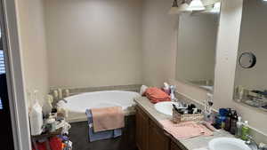 Master Bathroom featuring vanity and a bath with walk in shower