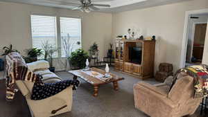 Carpeted living room with ceiling fan