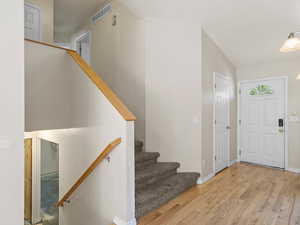 Entryway with lofted ceiling and light hardwood / wood-style floors