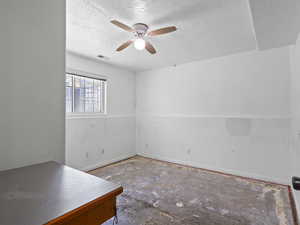 Downstairs bedroom ceiling fan, and a textured ceiling