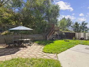 View of yard with a patio area and playhouse/treehouse, dog run