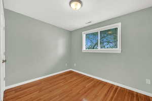 Unfurnished room with hardwood floors