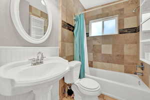 Full bathroom featuring shower / tub combo with curtain, toilet, and sink