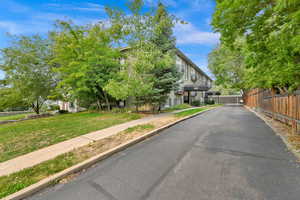 View of property hidden behind natural elements with a front yard