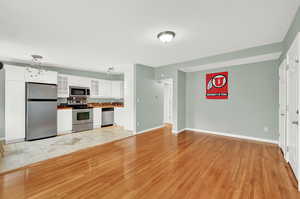 Kitchen with light tile flooring, stainless steel appliances, and white cabinets