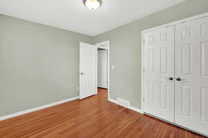 Unfurnished bedroom featuring light hardwood and a closet