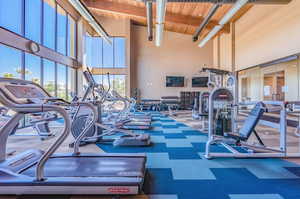 Gym with carpet flooring, high vaulted ceiling, and wooden ceiling