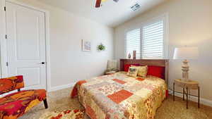 Carpeted bedroom featuring ceiling fan