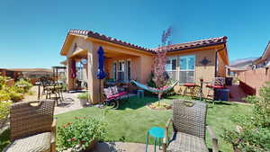 Back of house with a lawn, ceiling fan, and a patio area