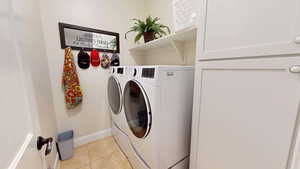 Laundry room with light tile patterned flooring and washer and clothes dryer