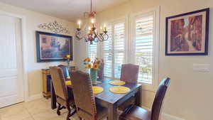 Dining space featuring light tile patterned floors and a notable chandelier