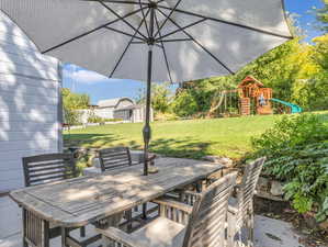 View of patio featuring a storage shed and a playground