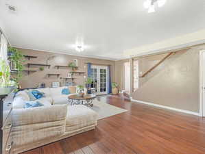 Living room with wood-type flooring and french doors