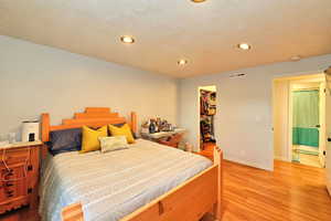 Bedroom with wood-type flooring, a closet, and a walk in closet